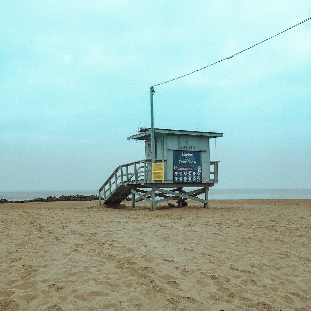 white lifeguard house on shore under blue sky