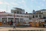 man in white and black shirt walking in front if store