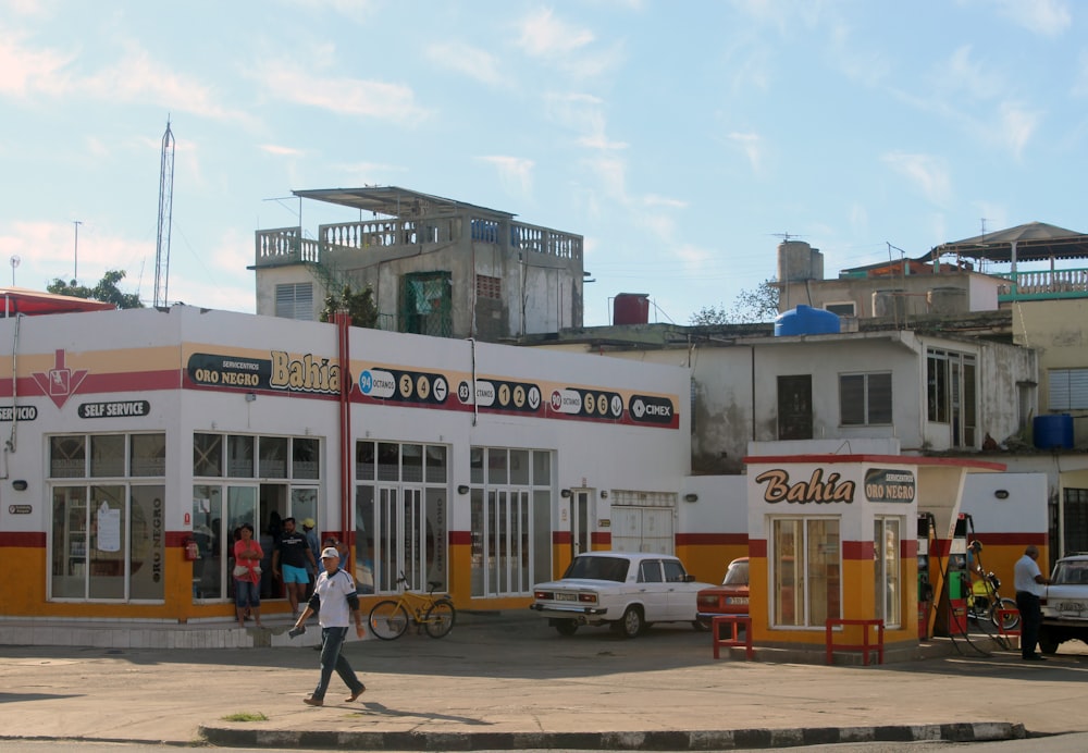 man in white and black shirt walking in front if store