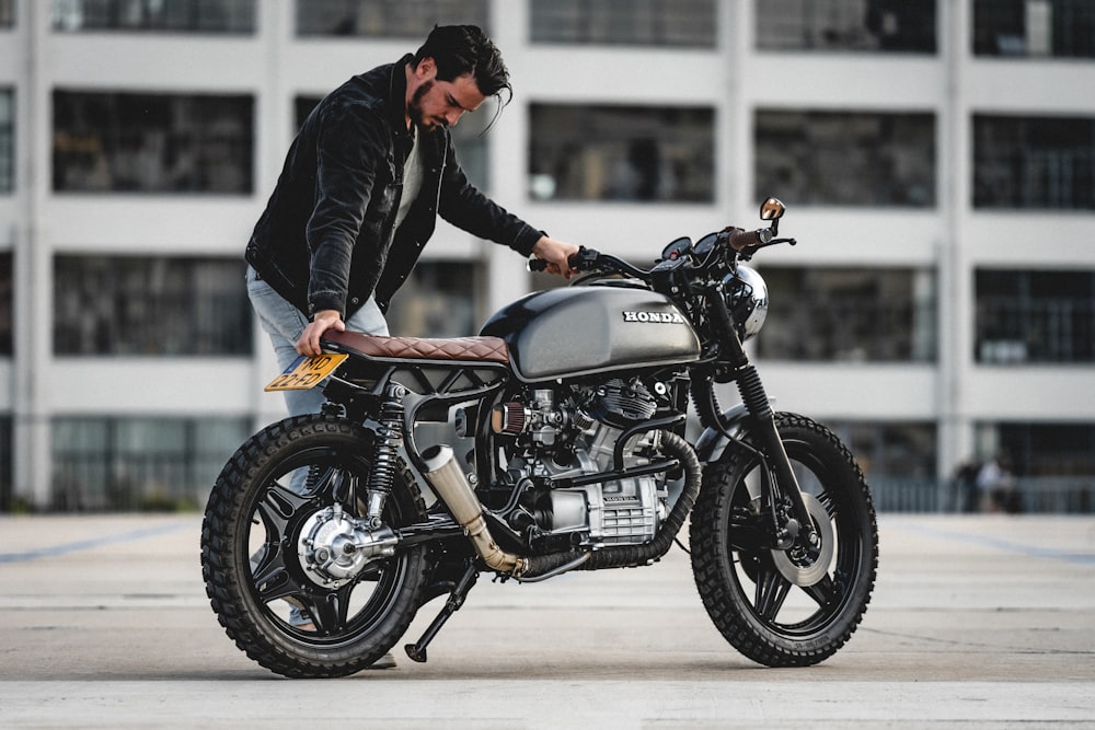 selective focus photography of man holding motorcycle