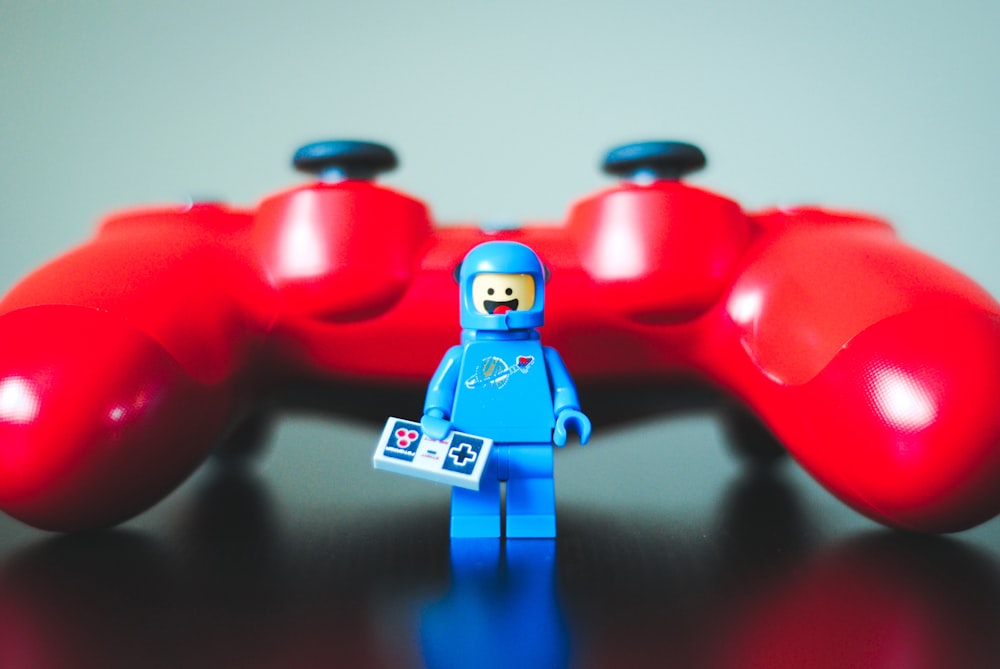 blue lego toy beside red game controller