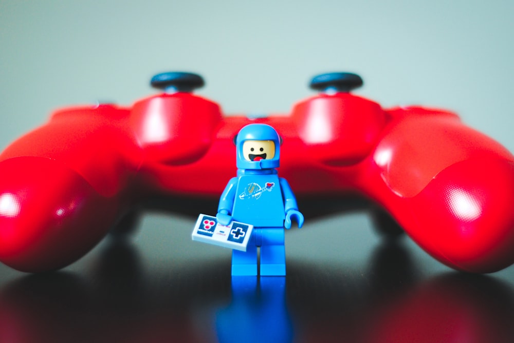 Blaues Lego-Spielzeug neben rotem Gamecontroller