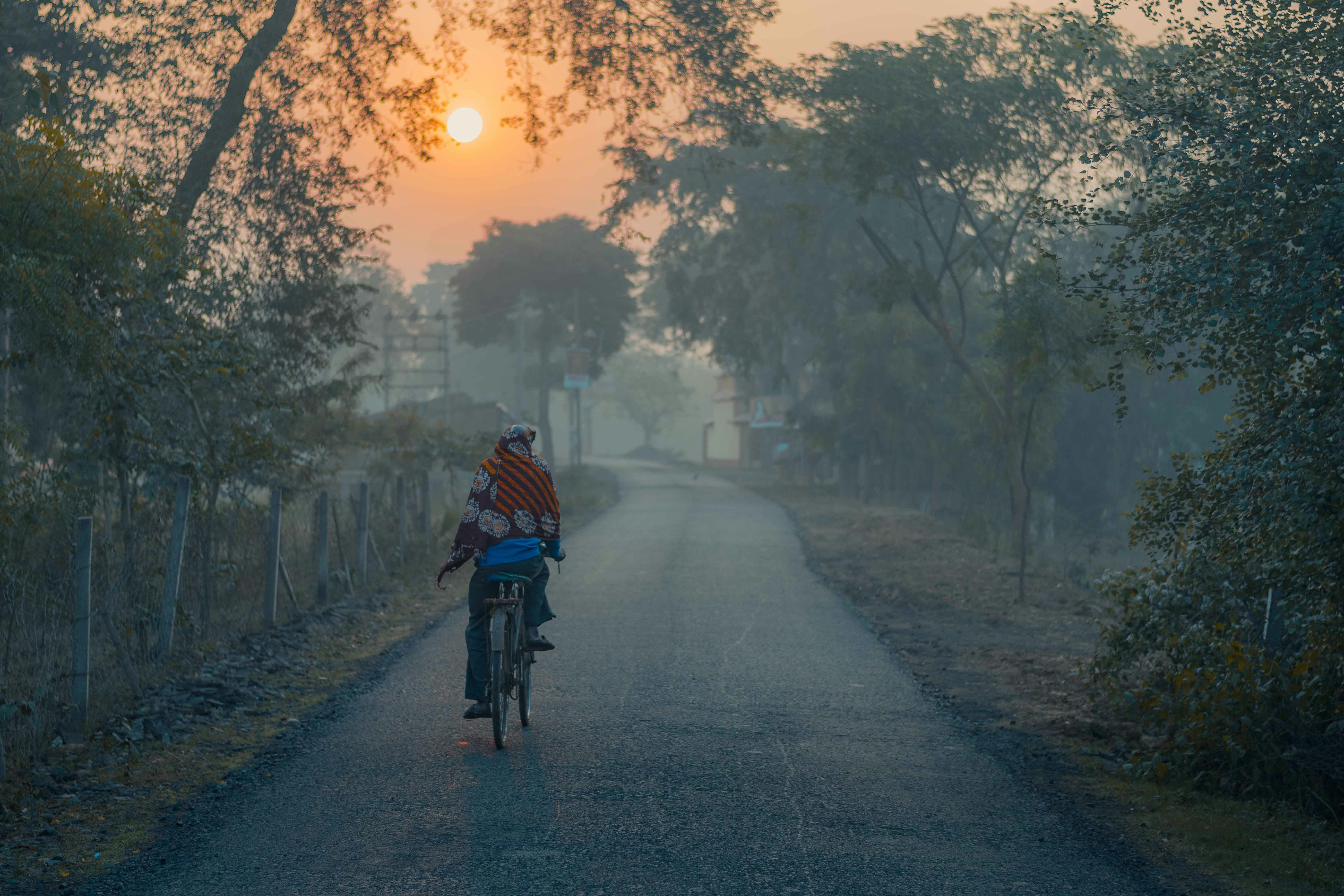 गर्मी से तपती सड़क पर मृगतृष्णा (मिराज) दिख रही है, और दूर क्षितिज पर सूरज आग का गोला जैसा लग रहा है