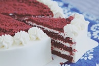 A rich red velvet cake with smooth cream cheese frosting and a dusting of cocoa powder.