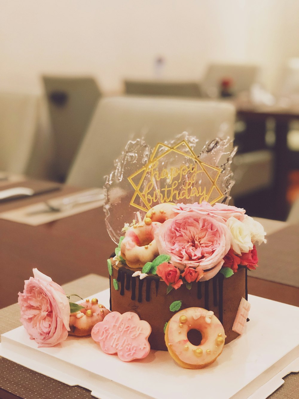 chocolate cake topped with roses and doughnuts