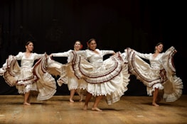 four women barefooted dancing on stage