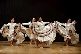 four women barefooted dancing on stage