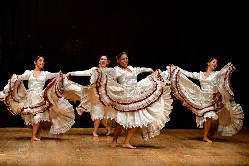 four women barefooted dancing on stage