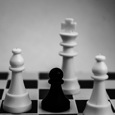 grayscale photo of king, pawn, and bishop chess pieces
