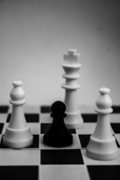 grayscale photo of king, pawn, and bishop chess pieces