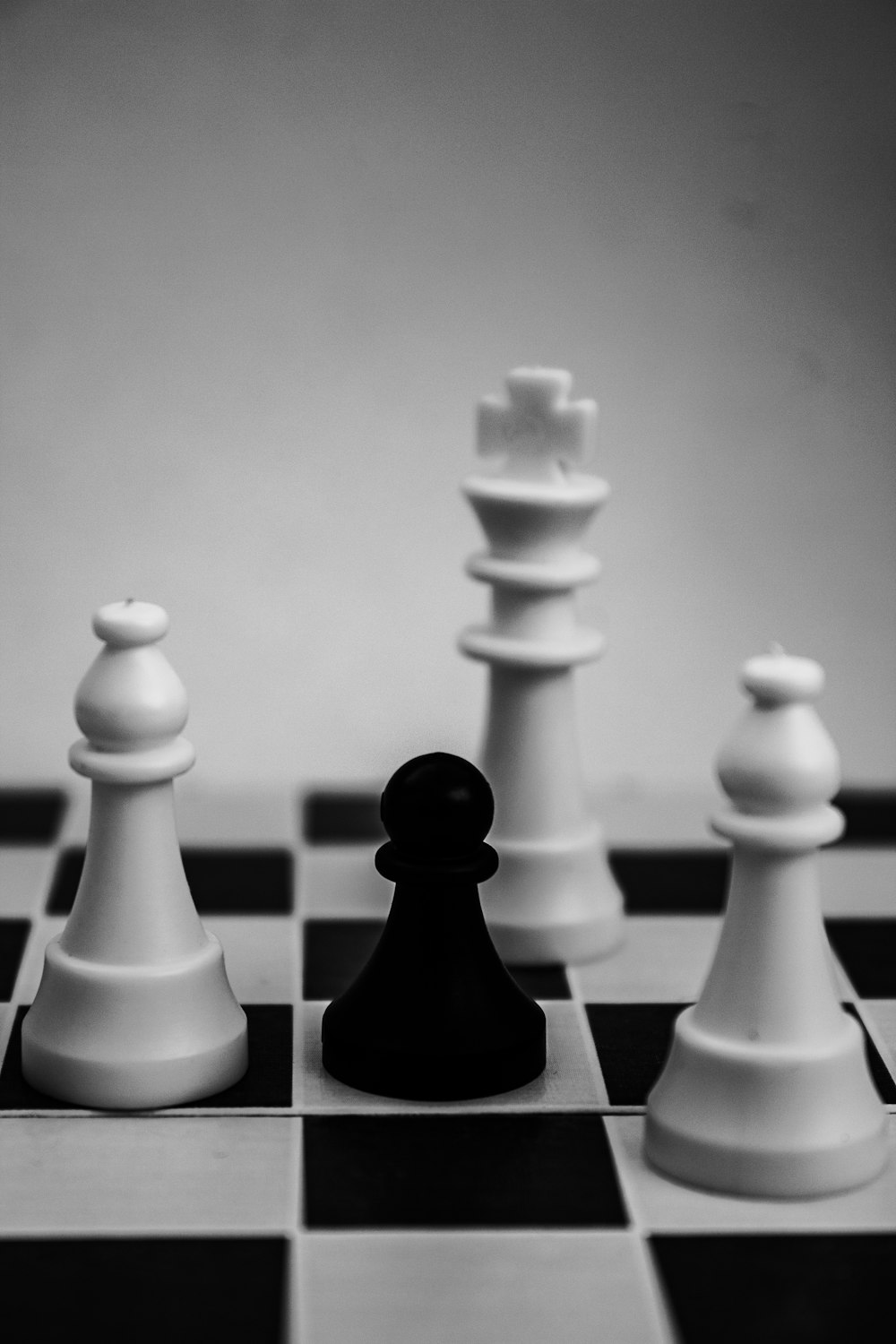 grayscale photo of king, pawn, and bishop chess pieces