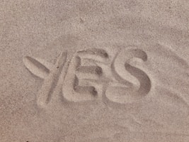 yes text on brown sand