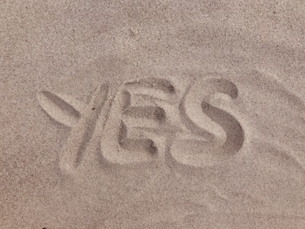 yes text on brown sand