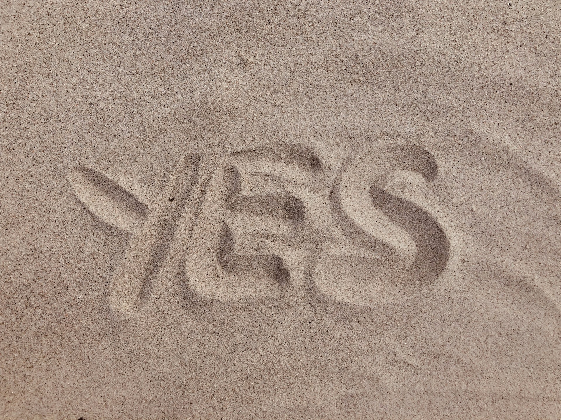 yes text on brown sand