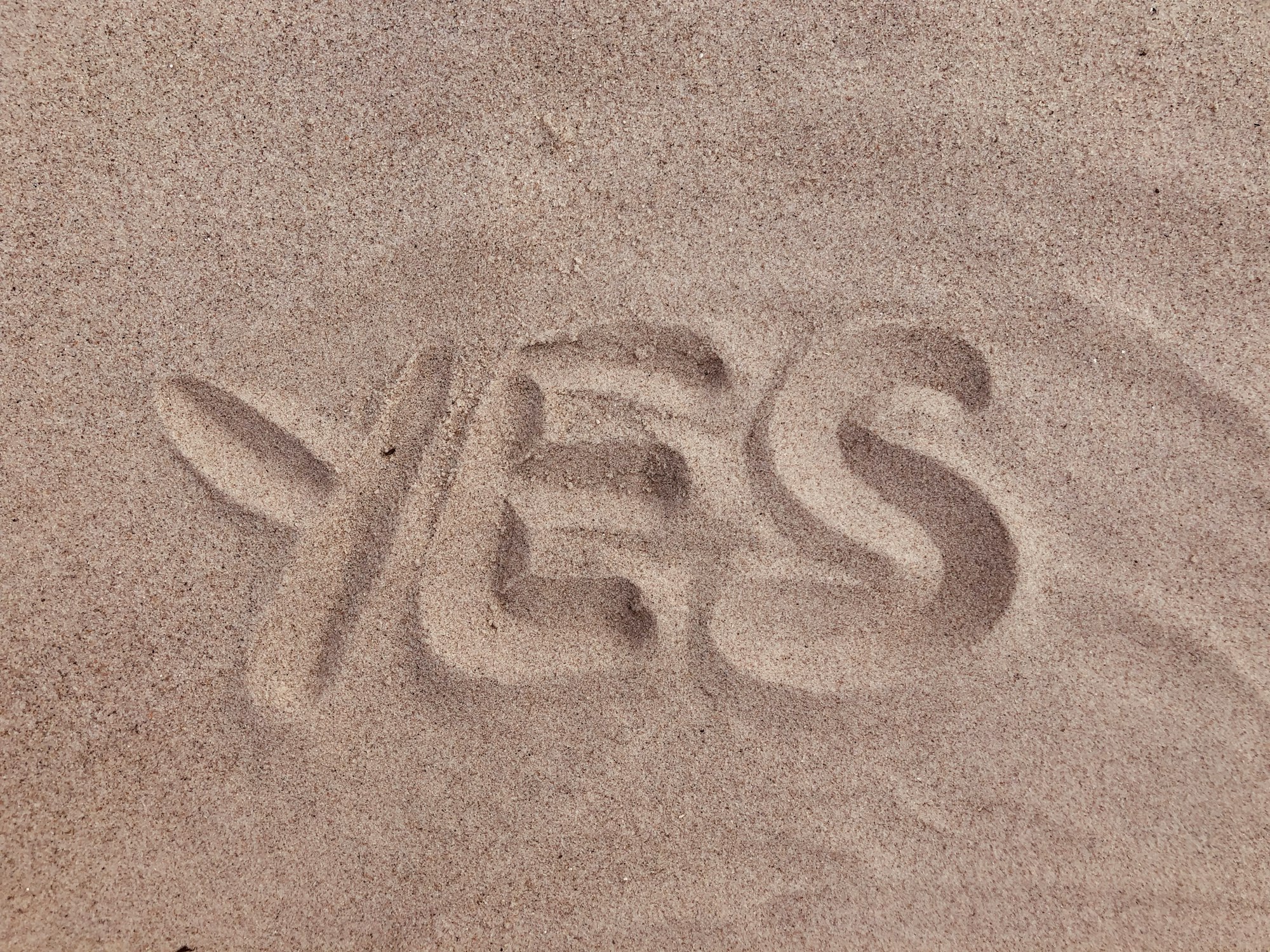 yes text on brown sand