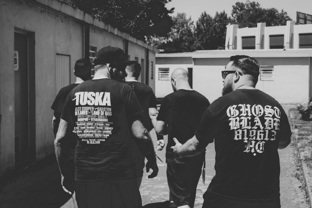 five men walking near house