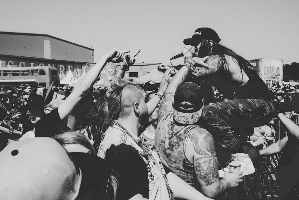 man performing on stage surrounded with people