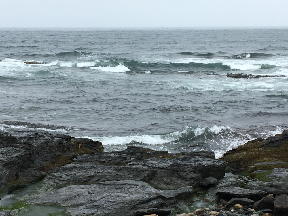 rocky hill viewing sea during daytime