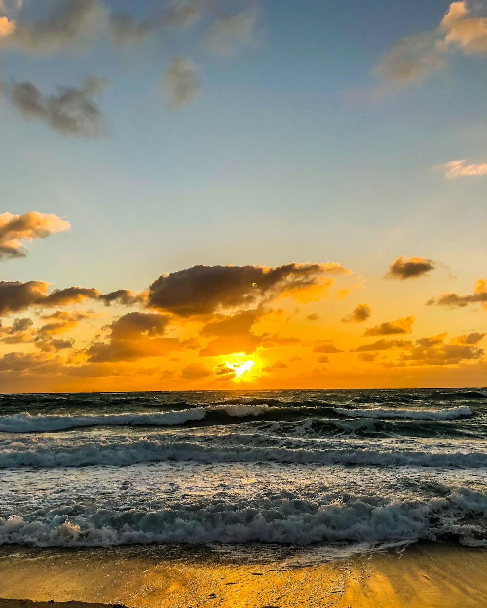 Mar en calma bajo cielos anaranjados y azules