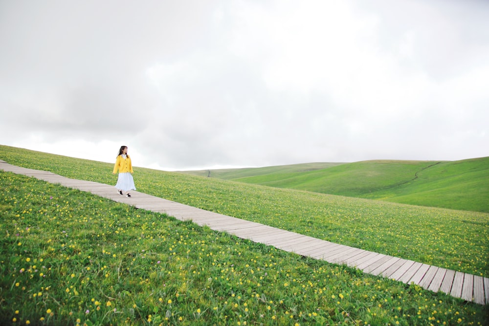 woman wearing skirt walking on pathway