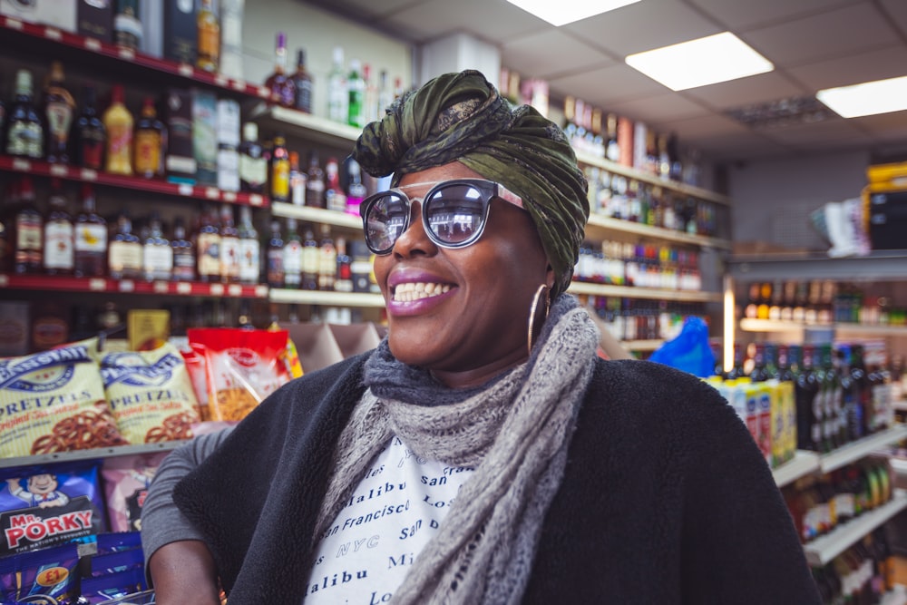 smiling woman wearing grey scarf and grey sunglasses