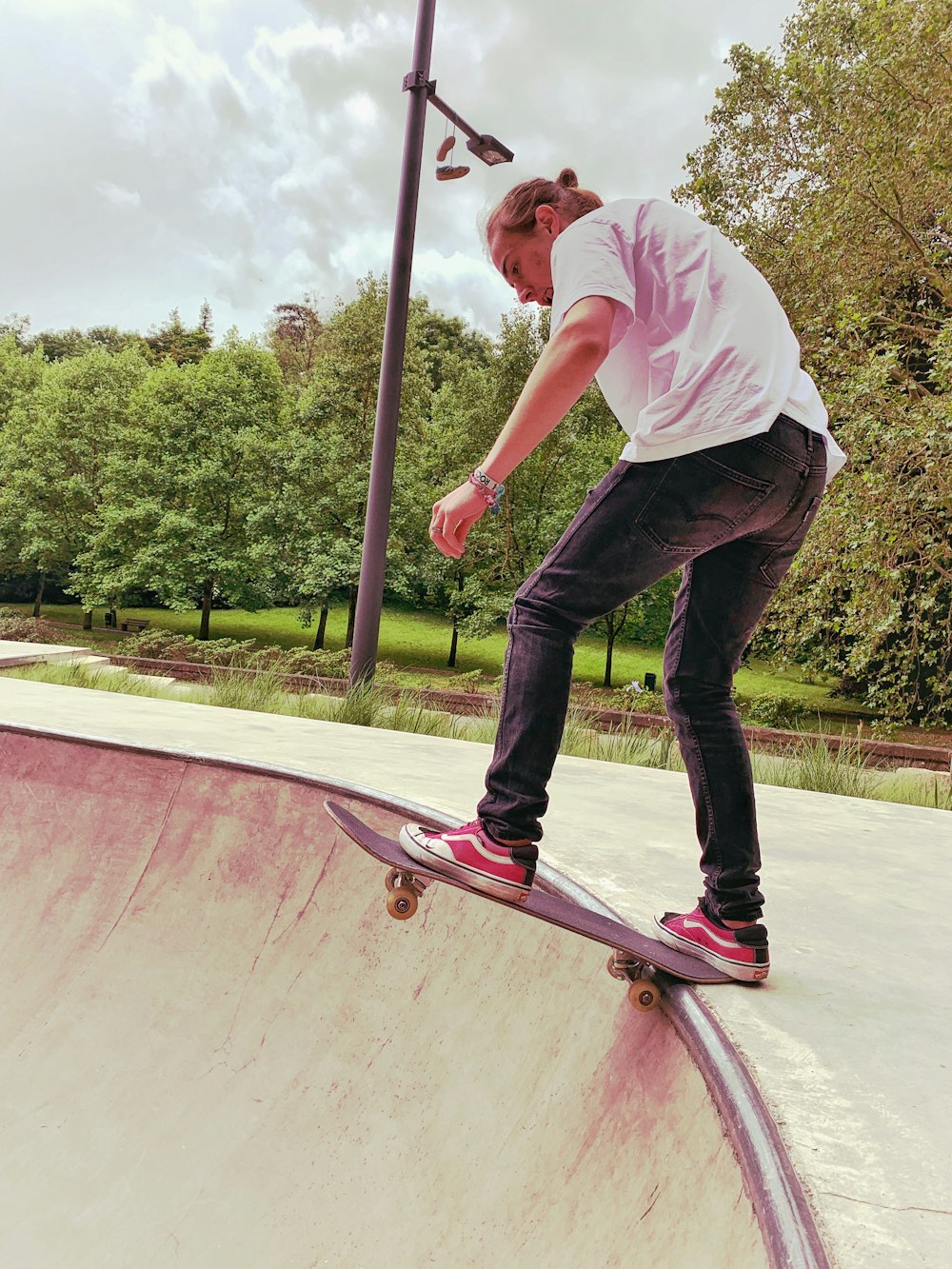 man wearing white shirt doing skateboard trick