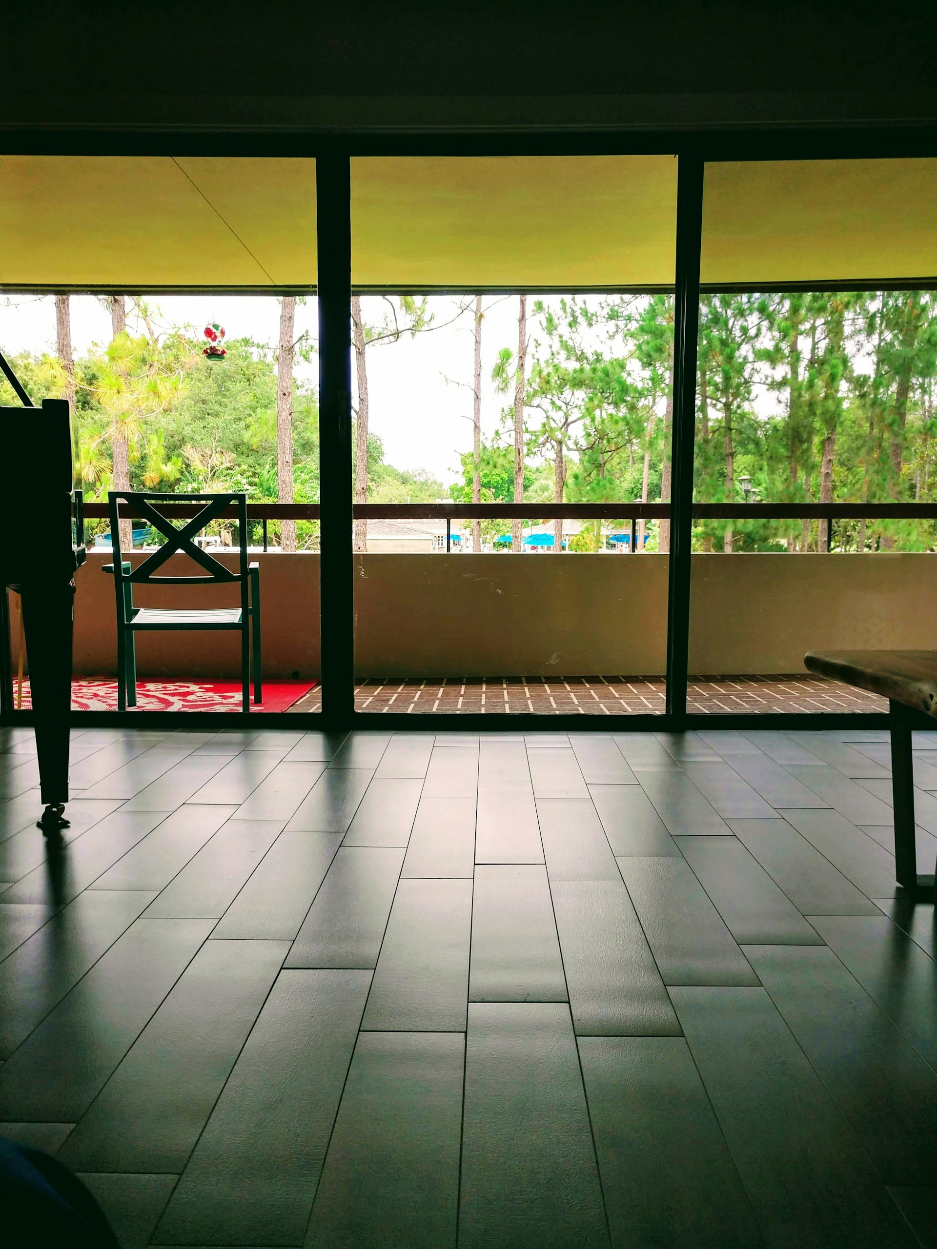 Modern open-plan living area with floor-to-ceiling windows framing the vibrant Balangan coastline.