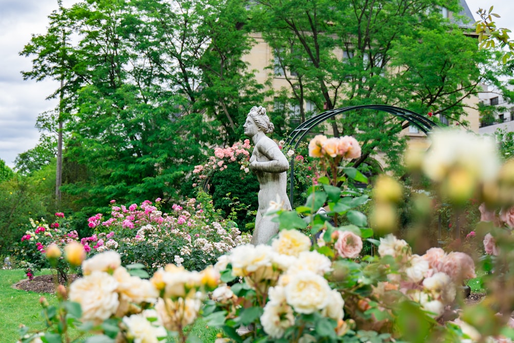 statue de femme près des plantes et des arbres
