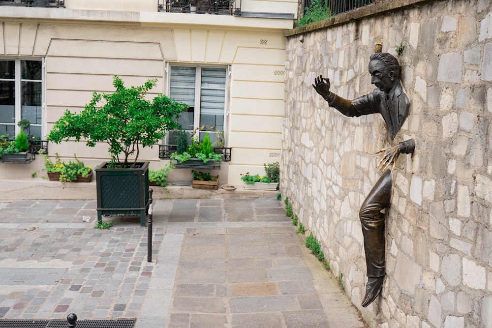 man trying to escape statue on wall