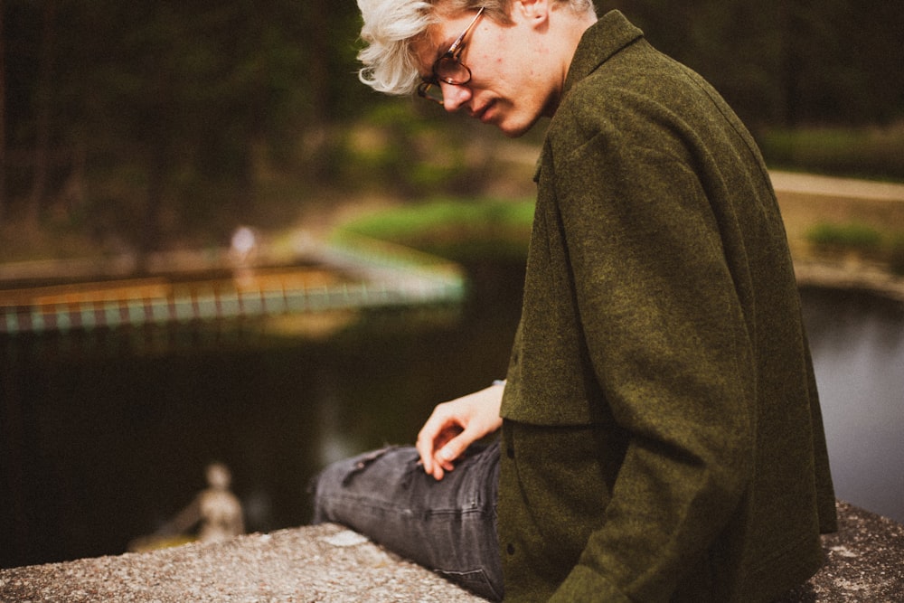 Man Wearing Green Jacket Sitting On Bench Photo Free Apparel