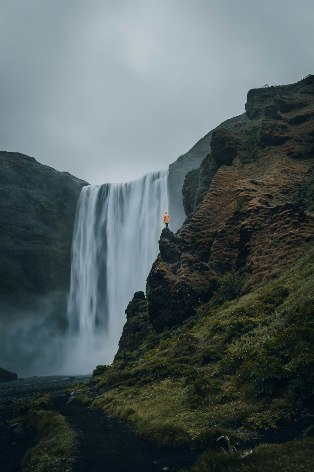 person standing near waterfalls