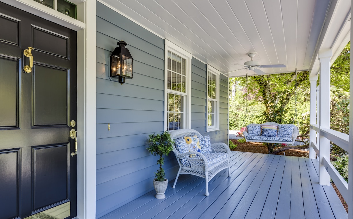 a porch with two chairs and a table on it