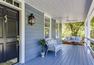 a porch with two chairs and a table on it