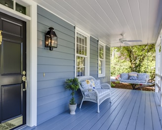 a porch with two chairs and a table on it