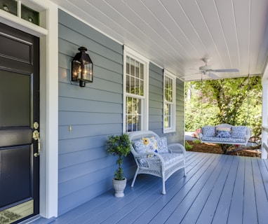 a porch with two chairs and a table on it