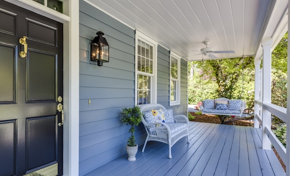 a porch with two chairs and a table on it