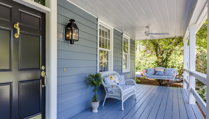 a porch with two chairs and a table on it