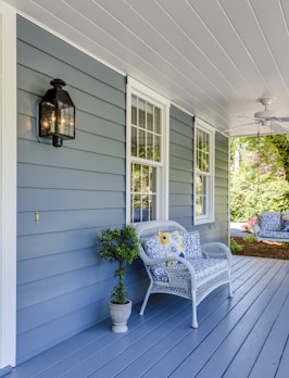 a porch with two chairs and a table on it