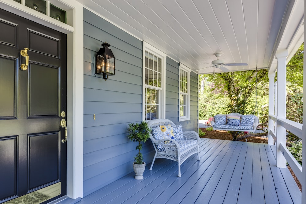 a porch with two chairs and a table on it