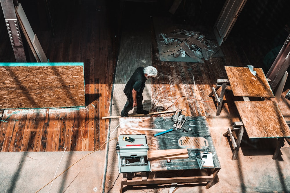 man standing beside brown wooden table