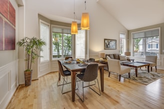 An inviting dining area with beautiful laminate flooring and decorative blinds.
