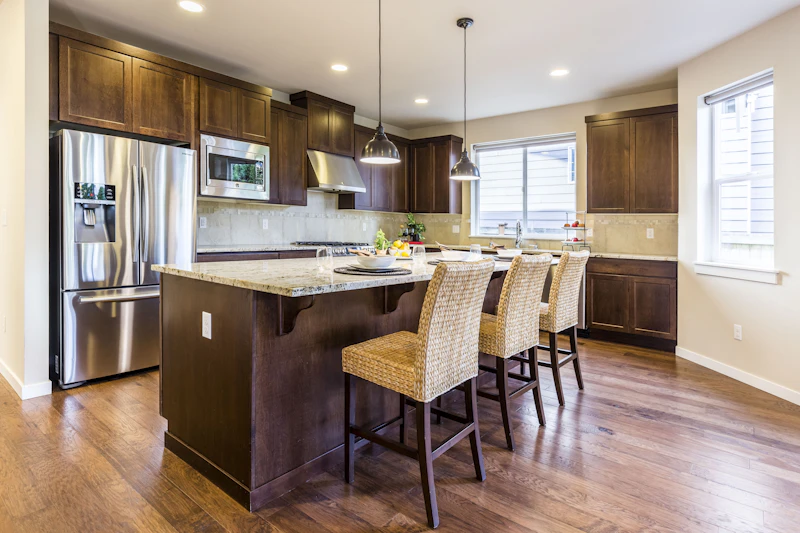 Kitchen with wood cabinets, a refrigerator, and seating at an island