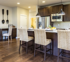 three brown wooden chairs in front of kitchen counter