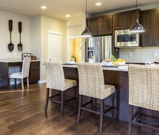 three brown wooden chairs in front of kitchen counter