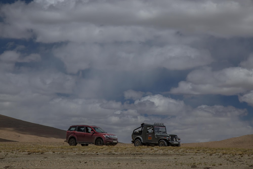 red SUV on brown hill