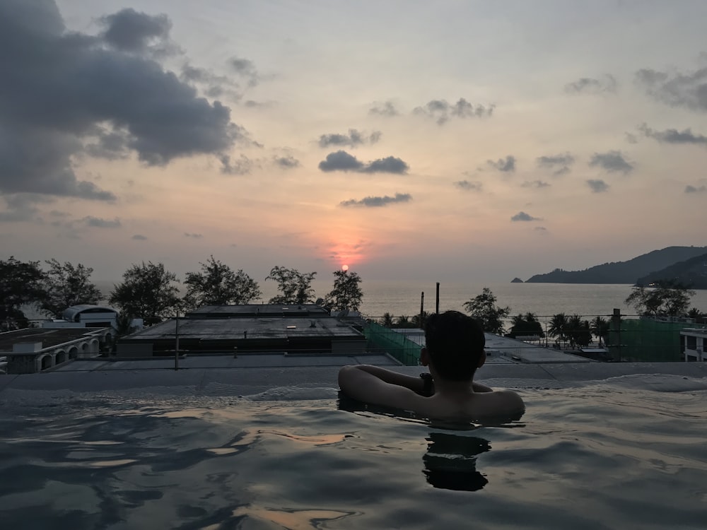 man in pool during golden hour