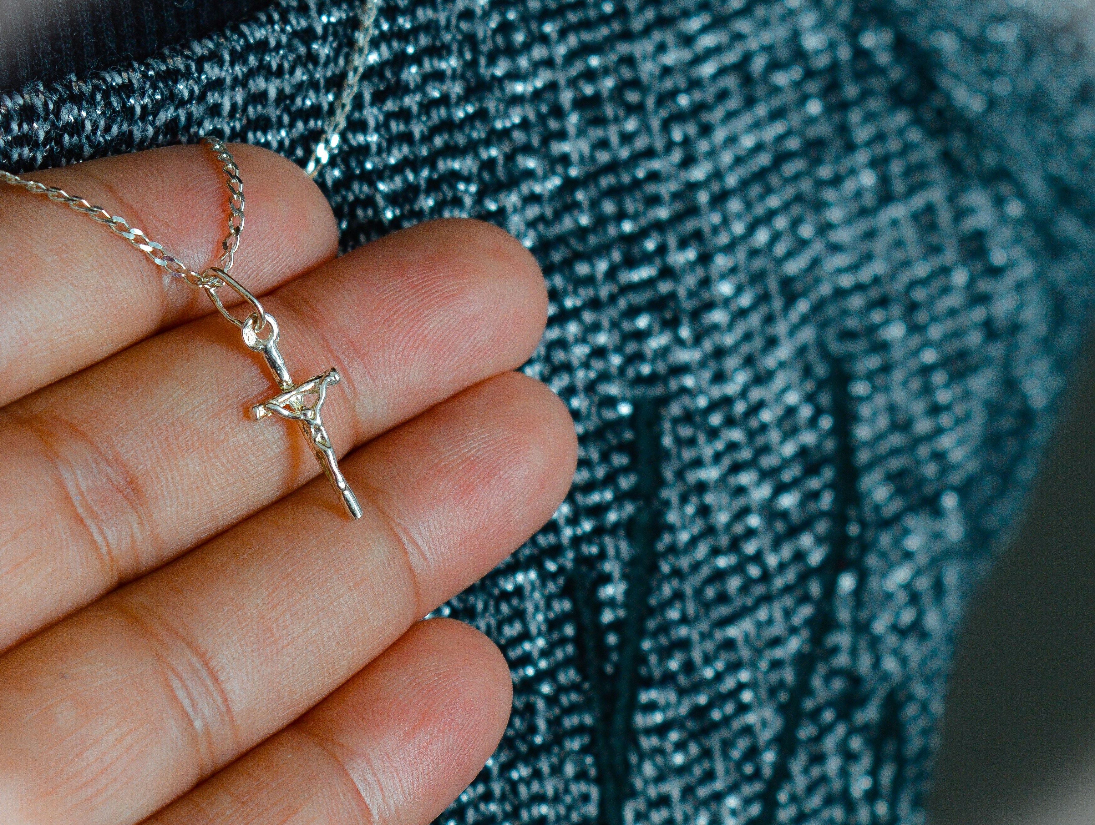 silver-colored chain necklace with crucifix pendant