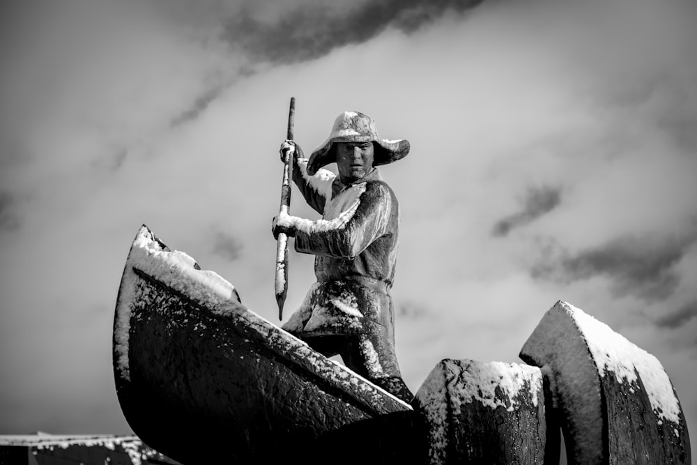 grayscale photography of man standing on boat