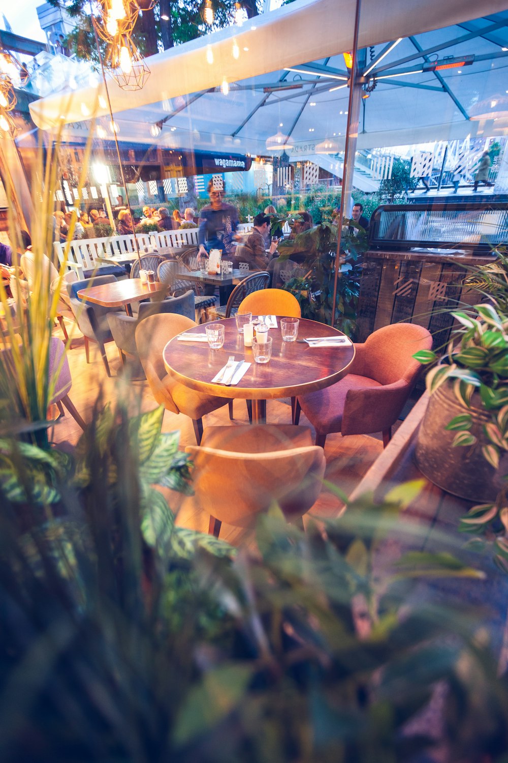 round brown wooden table with white umbrella