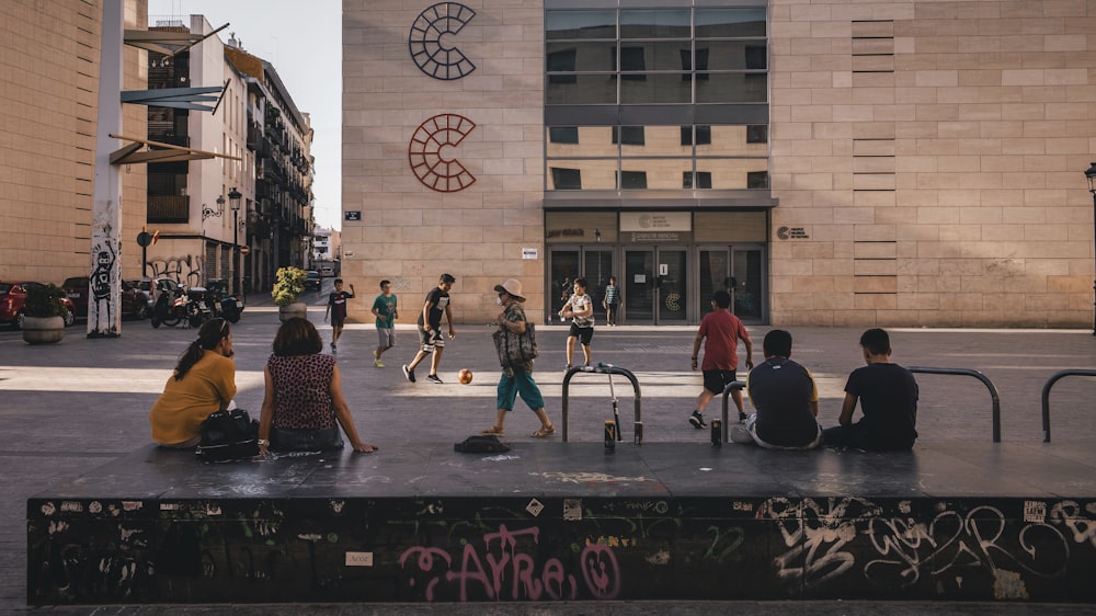 two women sitting on bench talking and watching people playing